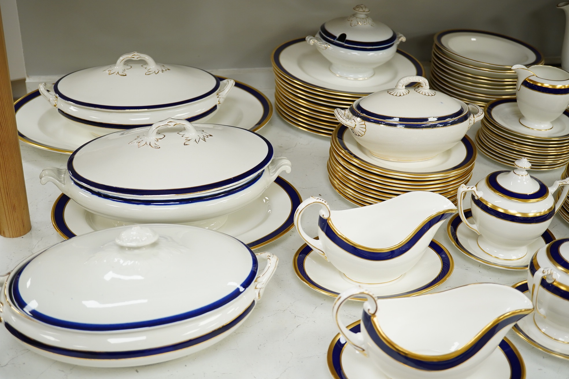 A large part Coalport ‘Rutland’, gilt and blue banded dinner and coffee service, coffee pot and cover 24cm high. Condition - the dinner service is for twelve place settings, the coffee set ten place settings. Condition -